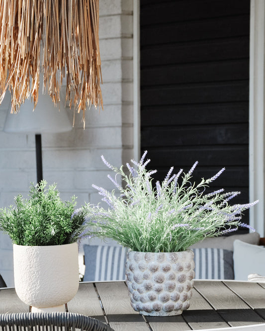 UV-protected artificial plants, lavender and rosemary in decorative planters on a terrace table. Lifelike plants bring greenery without watering