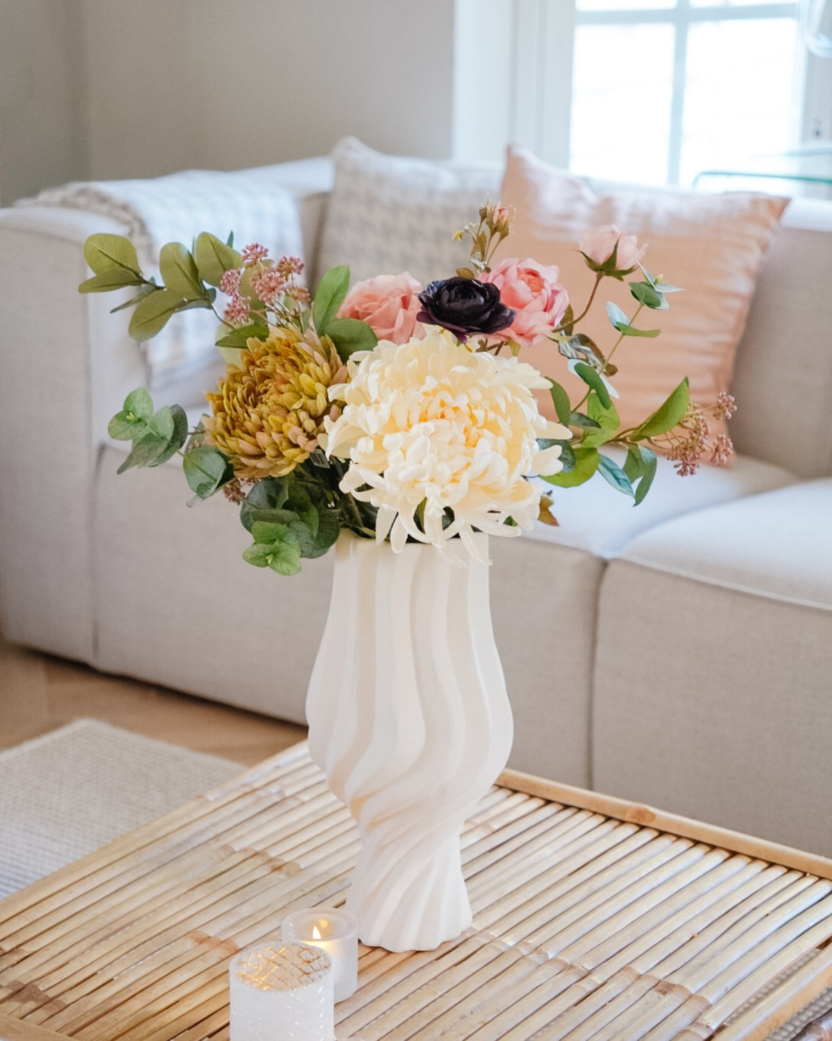 Amara silk flower bouquet in a white vase on a living room table