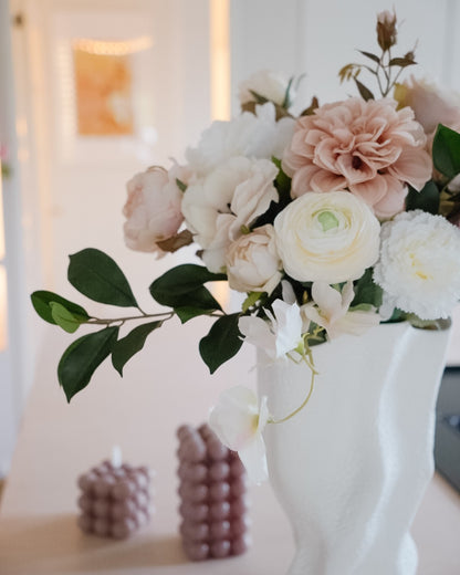 Close-up of dusty pink and white flowers and green leaves in the Estelle silk bouquet