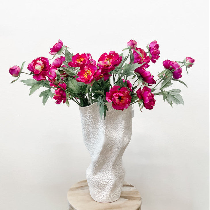 Several fuchsia silk peony branches in a vase