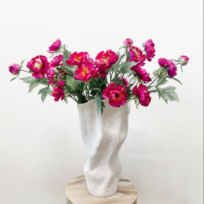 Several fuchsia silk peony branches in a vase