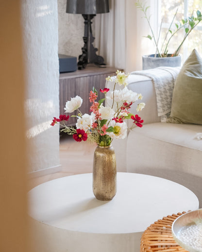 Saga silk flower bouquet in a gold vase on a living room coffee table