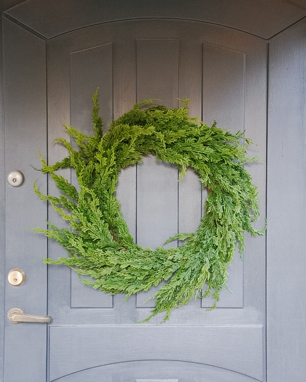 Large 55 cm silk evergreen wreath on a grey door, front view
