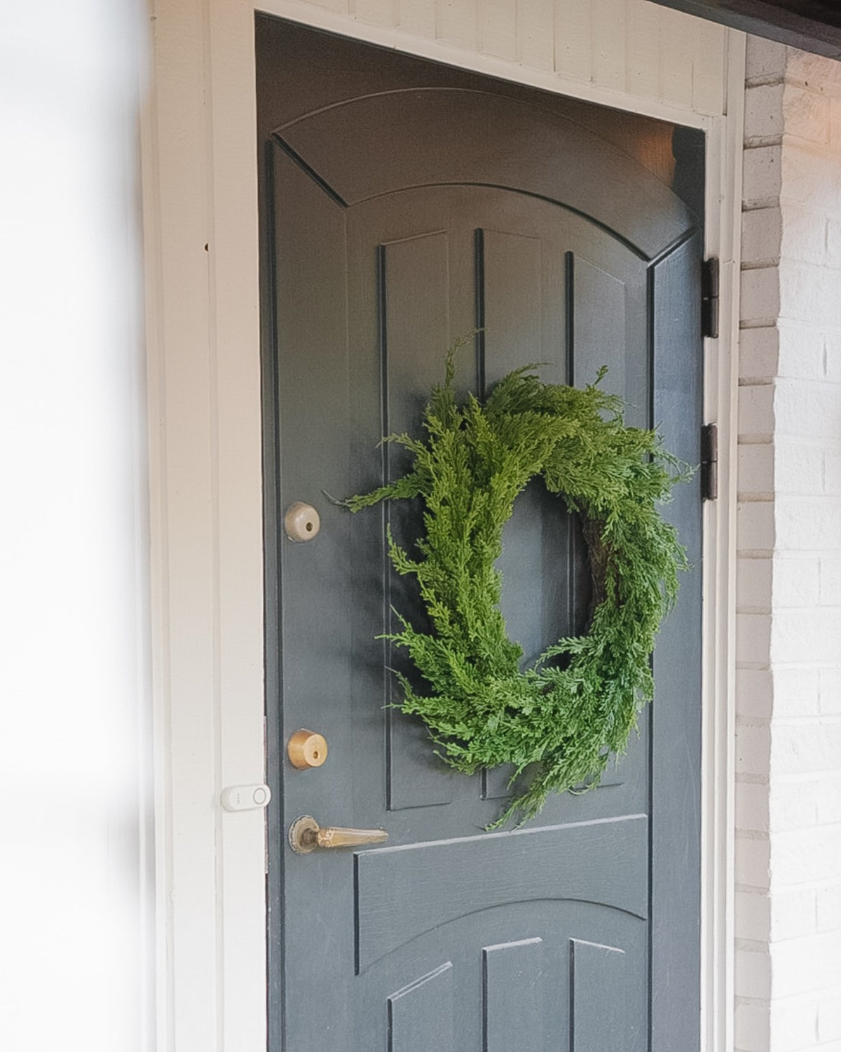 Large green 55 cm silk evergreen wreath on a grey front door