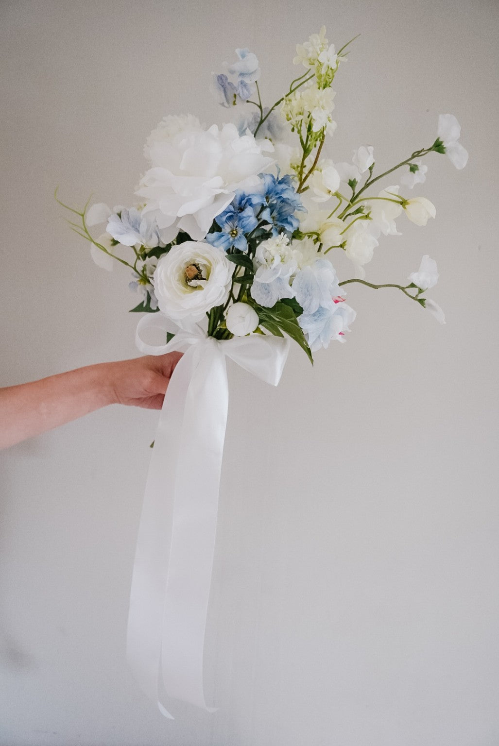 Blue and white silk wedding bouquet with a long white satin ribbon